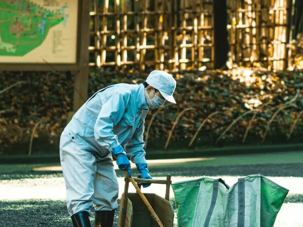 Technician in protective gear at a ground nest on a lawn